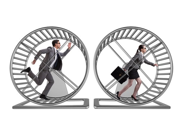 man and woman running in hamster wheels