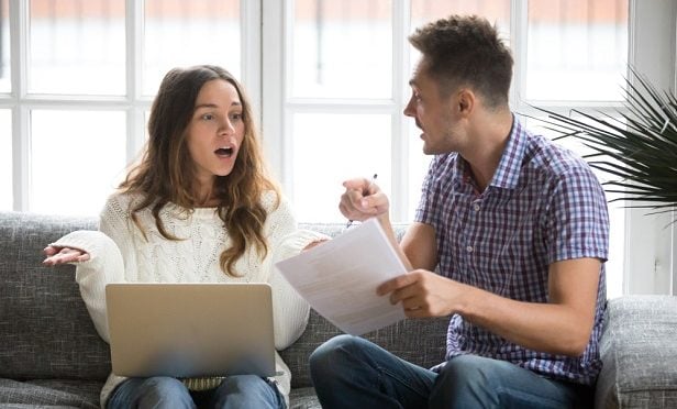 man and woman arguing over bills