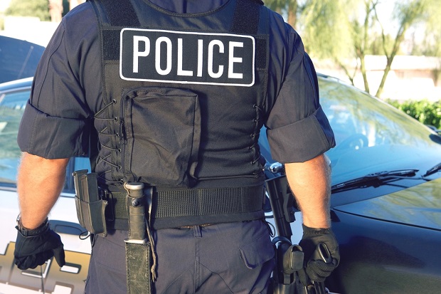 generic photo of the back of a man in police uniform