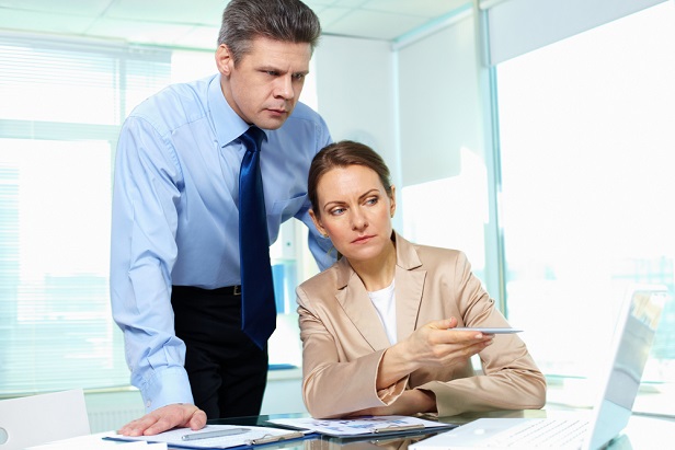male and female CEO in front of computer looking worried