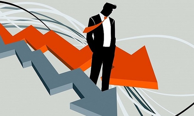 Businessman standing between two downward-trending arrows