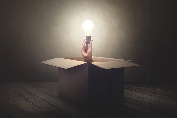 box with hand sticking out and holding lightbulb