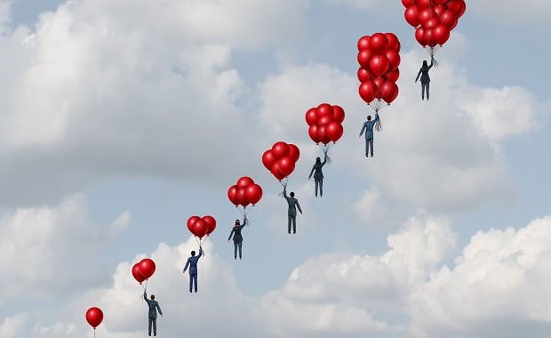 Businessmen being carried away by balloons