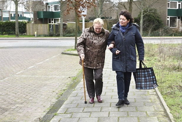 older woman and elderly woman walking arm in arm