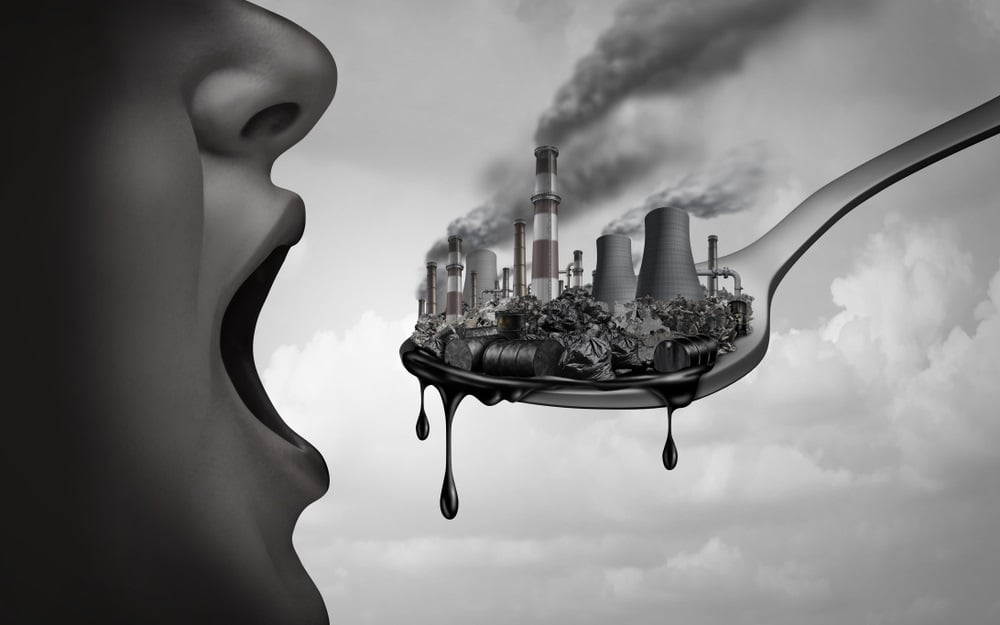Surreal drawing of person's mouth being fed a spoon with polluted factories on it