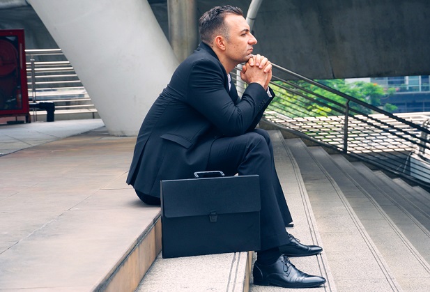 business man sitting on steps thinking