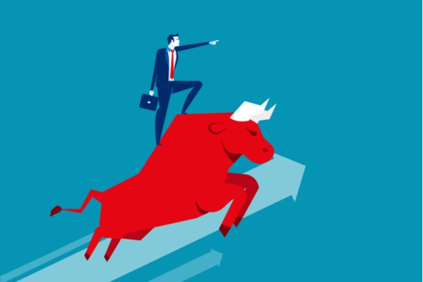 cartoon like image of man in suit standing atop a running bull