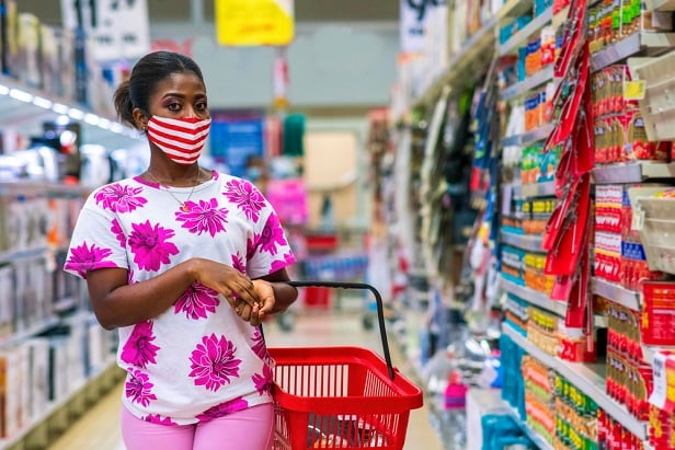 woman wearing mask as she shops in supermarket aisle