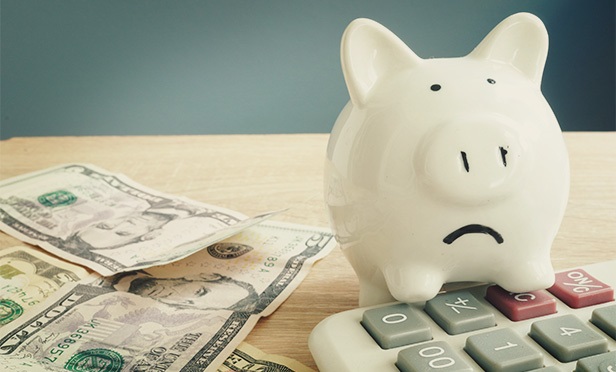 frowning white piggy bank on money and calculator
