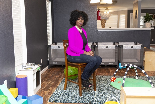 woman sitting in the middle of her home daycare space
