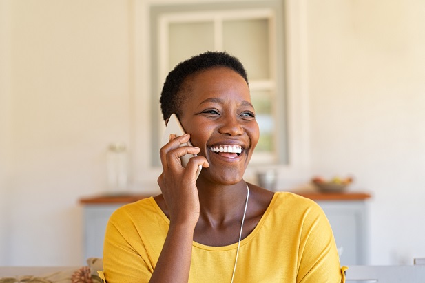 woman smiling as she talks on phone