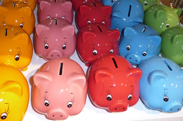 many colors of piggy banks in rows on shelf