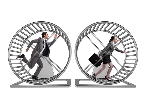 business man and woman running on hamster wheels