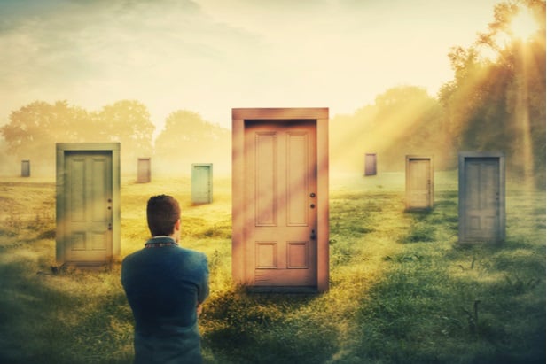 man looking at door in the middle of a field