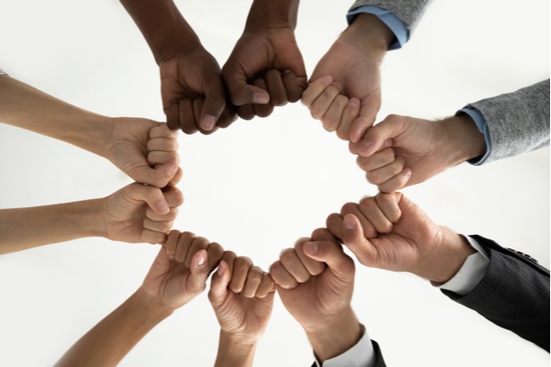 hands and fists of various people forming a diverse circle
