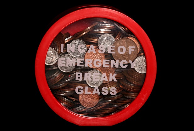 glass container holding coins with 'in case of emergency' typical message on glass