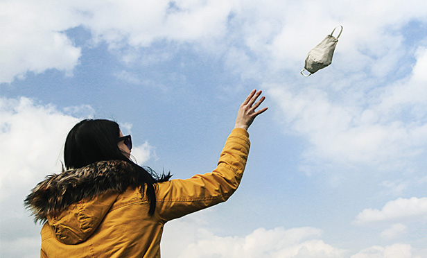 Man throwing away mask