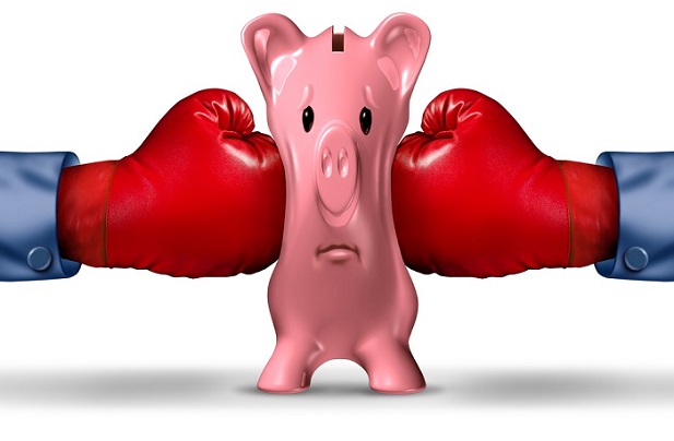 boxing gloves squeezing a pink piggy bank