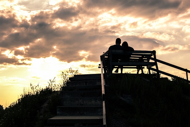couple on bench watching sunset