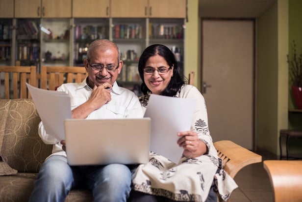 older couple looking at financial data while sitting on sofa