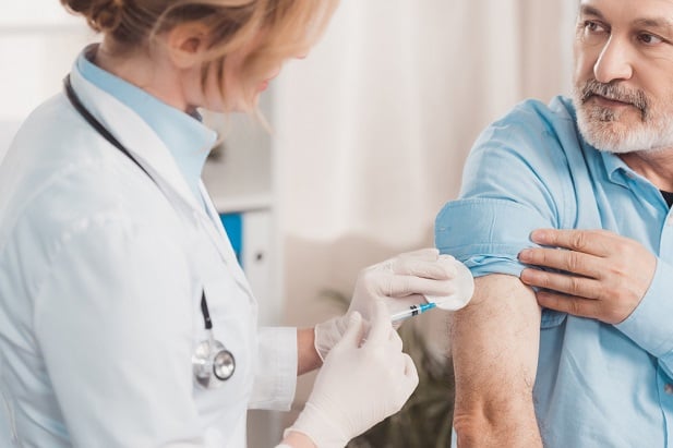 health professional giving man a vaccine in arm