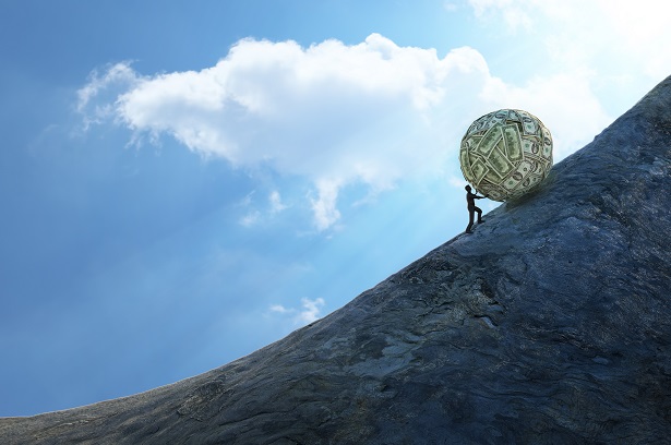 person rolling ball of money up a steep hill