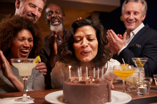woman blowing out candles on cake