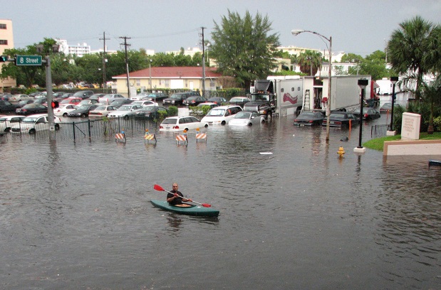 man in kayak on flooded South Beach, FL street