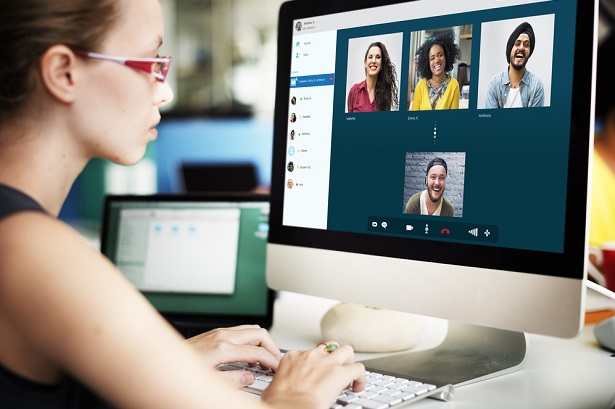 woman interacting on computer with coworkers