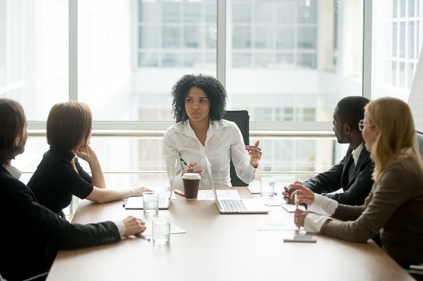 Black female boss leading corporate team briefing in boardroom