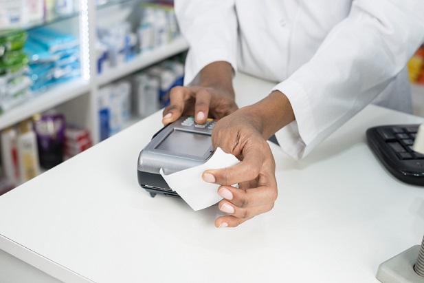 closeup of pharmacist offering receipt