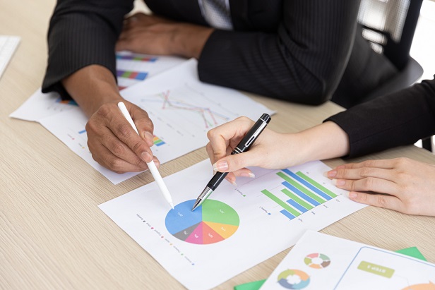 closeup of two business people pointing at charts