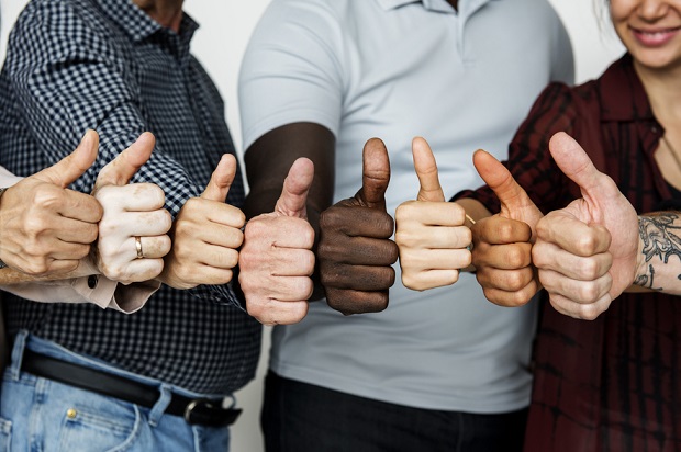 closeup of diverse employees giving a thumbs up