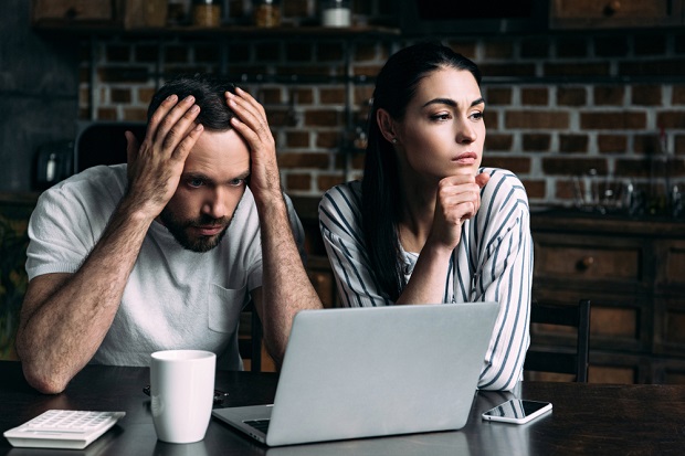 couple at laptop looking upset