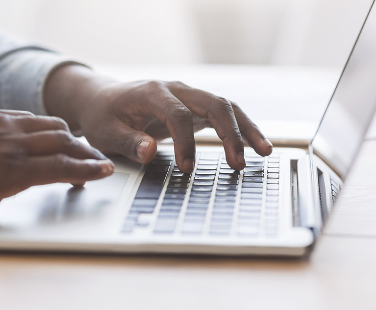 Unrecognizable african american man typing on laptop keyboard in office