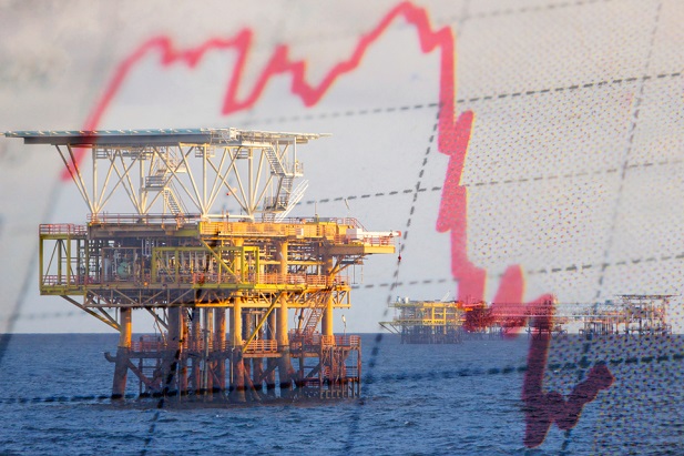 oil rigs drilling over ocean with falling red chart line superimposed