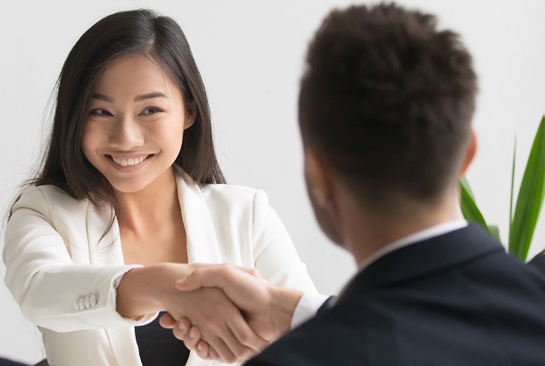 female insurance pro shaking hands with client