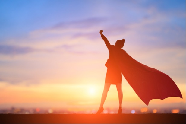 silhouetted woman in business suit wearing superman cape