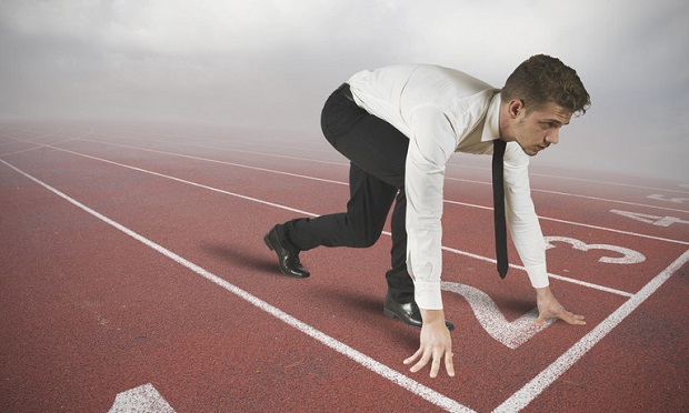 Businessman on race track in sprint position