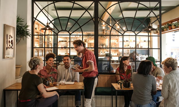 Waiter taking orders from customers sitting in a bistro