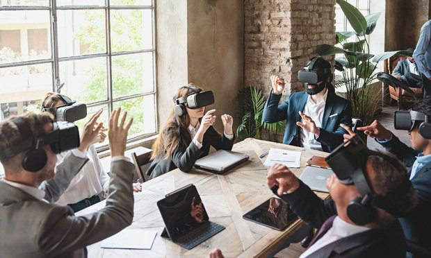 Group of businessperson exploring a virtual project wearing 360 3d vr goggles and sitting around the table - people meets in metaverse reality - business lifestyle concept. Credit: G. Lombardo/Adobe Stock