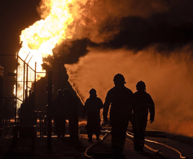 Firemen Walking Toward an industrial fire