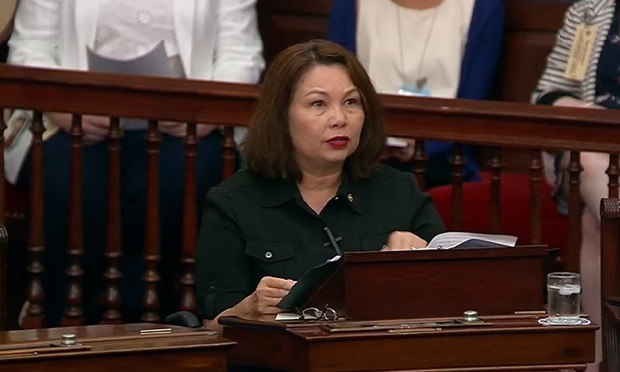 Sen. Tammy Duckworth, D-Ill., stands at a wooden lectern on the Senate floor.