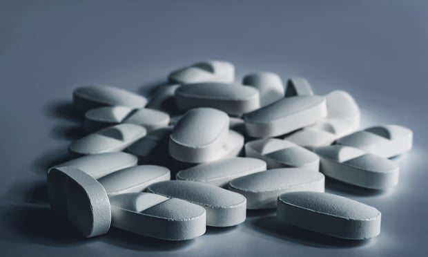 Closeup of many white prescription drugs, medicine tablets or vitamin pills in a pile - Concept of healthcare, opioids addiction, medicament abuse or medication treatment