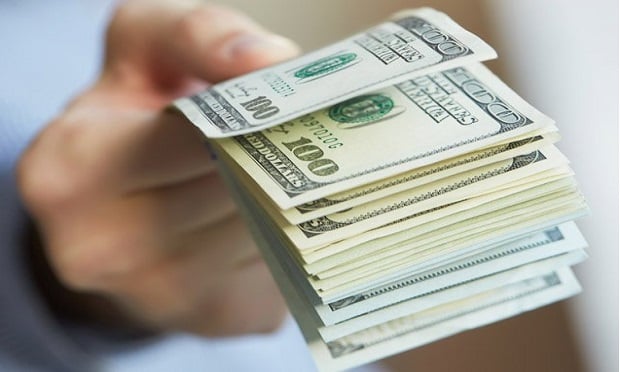 A hand providing a wad of cash