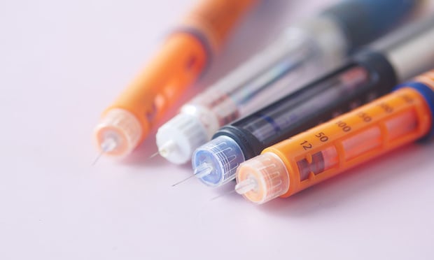 Insulin pens on color background, close up