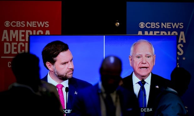 JD Vance and Tim Walz on a big screen.