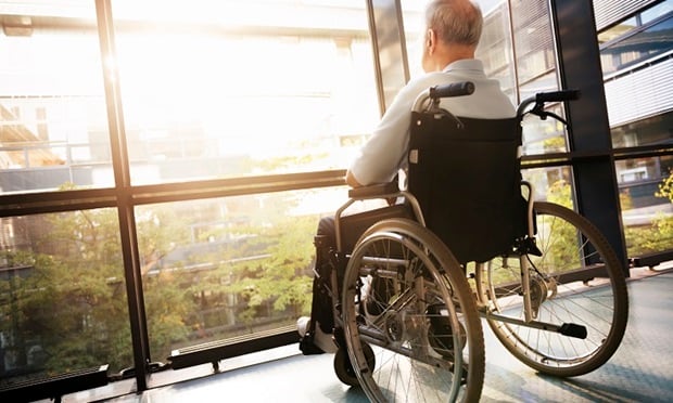 A man in a wheelchair looking out a window