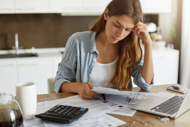 Woman looking at bills worrying how she will pay. 