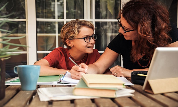 Parent helping a child with schoolwork.